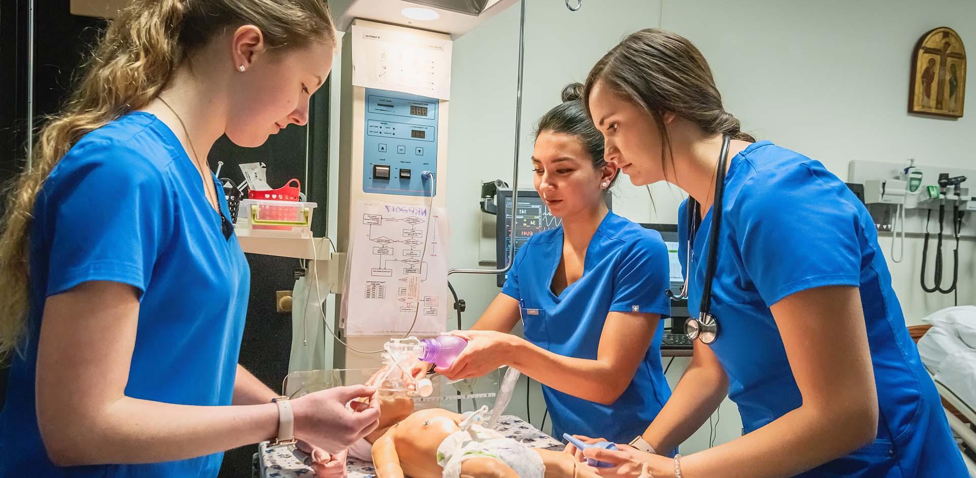 Nursing students practicing clinical skills on simulator